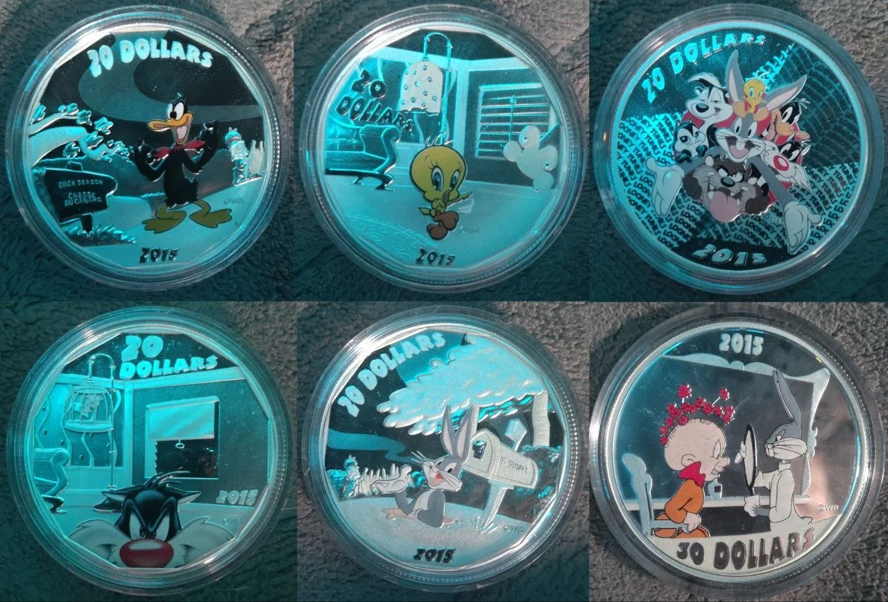 Six collectible coins featuring Looney Tunes characters, with designs including Daffy Duck, Tweety Bird, and Bugs Bunny, each marked with 20 dollars and 2015.