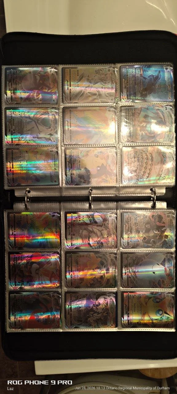 Collection of holographic Pokémon trading cards in a binder with transparent sleeves.
