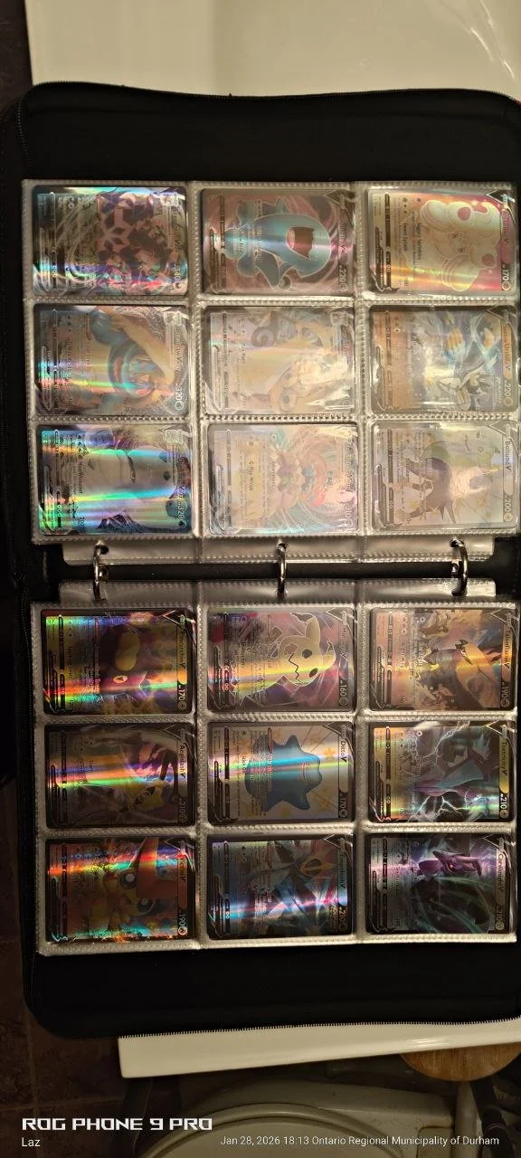 Collection of Pokémon cards in a binder, featuring various holographic cards including Pikachu, Charizard, and other characters.