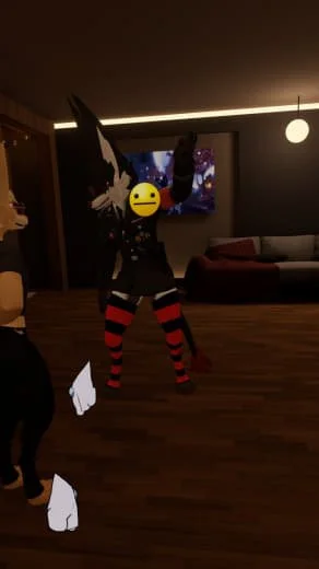 Person wearing a black and white costume with a character mask, red and black striped stockings, standing in a living room with a television and a sofa.