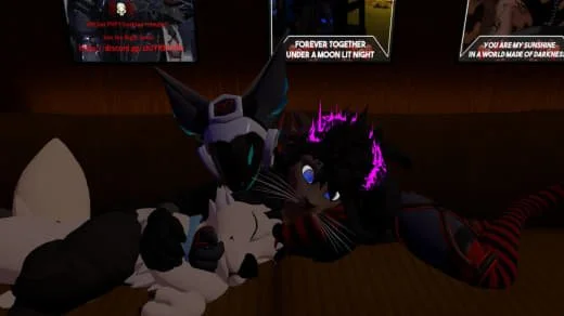 A furry black cat with purple hair and blue eyes lying on a wooden surface, with a white and black plush toy, in a room with movie posters on the wall.