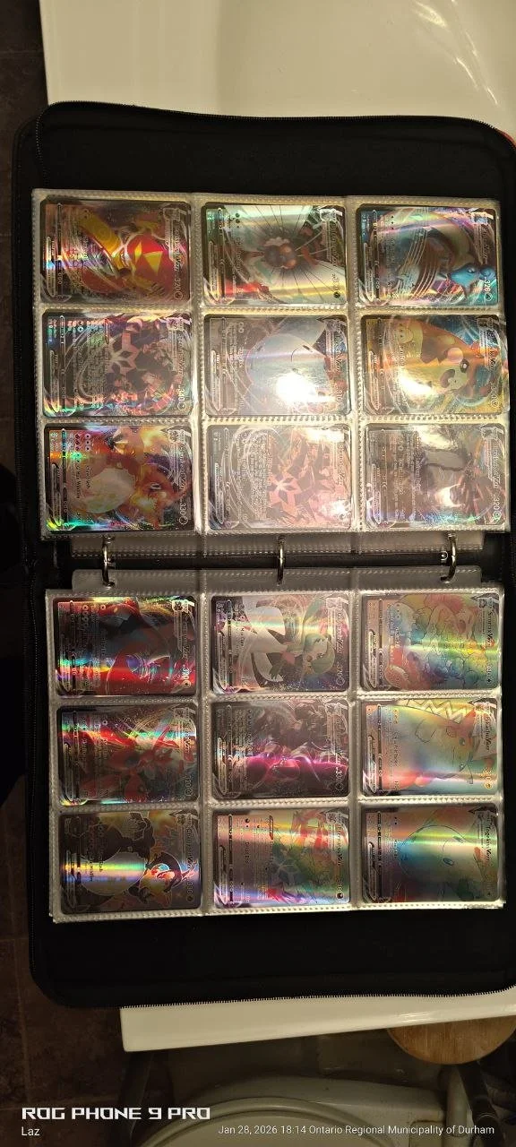 A collection of Pokémon trading cards in a binder, all with holographic designs.