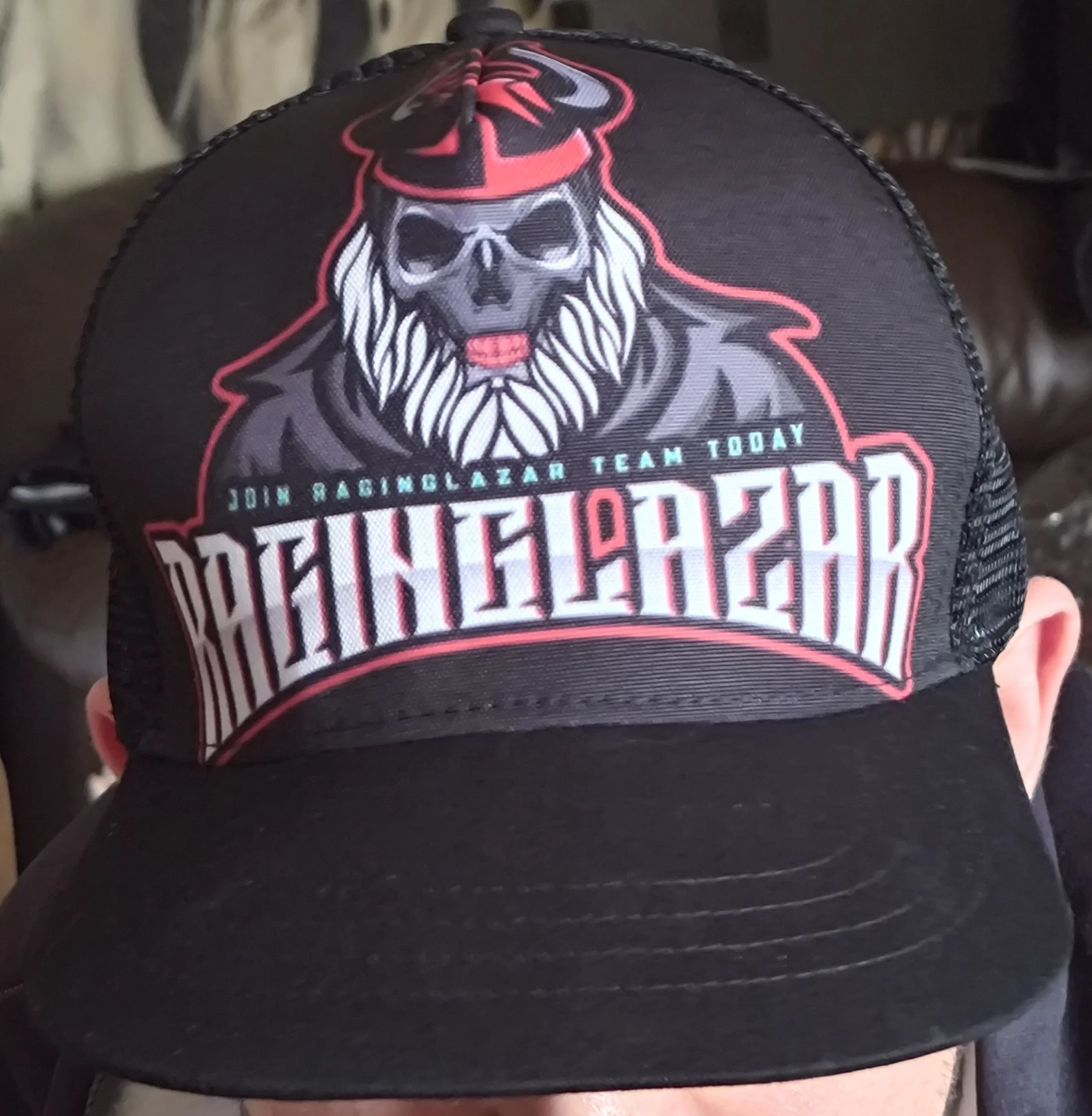A black cap with a graphic of a skull wearing sunglasses, a cap, and a beard, along with text that reads 'Join Raciborz Team Today' and 'RACIBORZ' in uppercase letters.