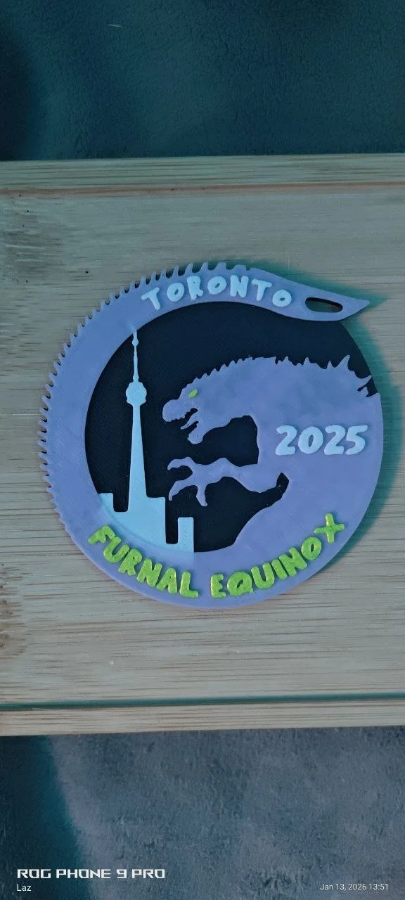 A circular saw blade-shaped sign with the words 'TORONTO' at the top, a dinosaur silhouette in the center, '2025' on the right, and 'FURINAL EQUINOX' at the bottom, on a wooden surface.