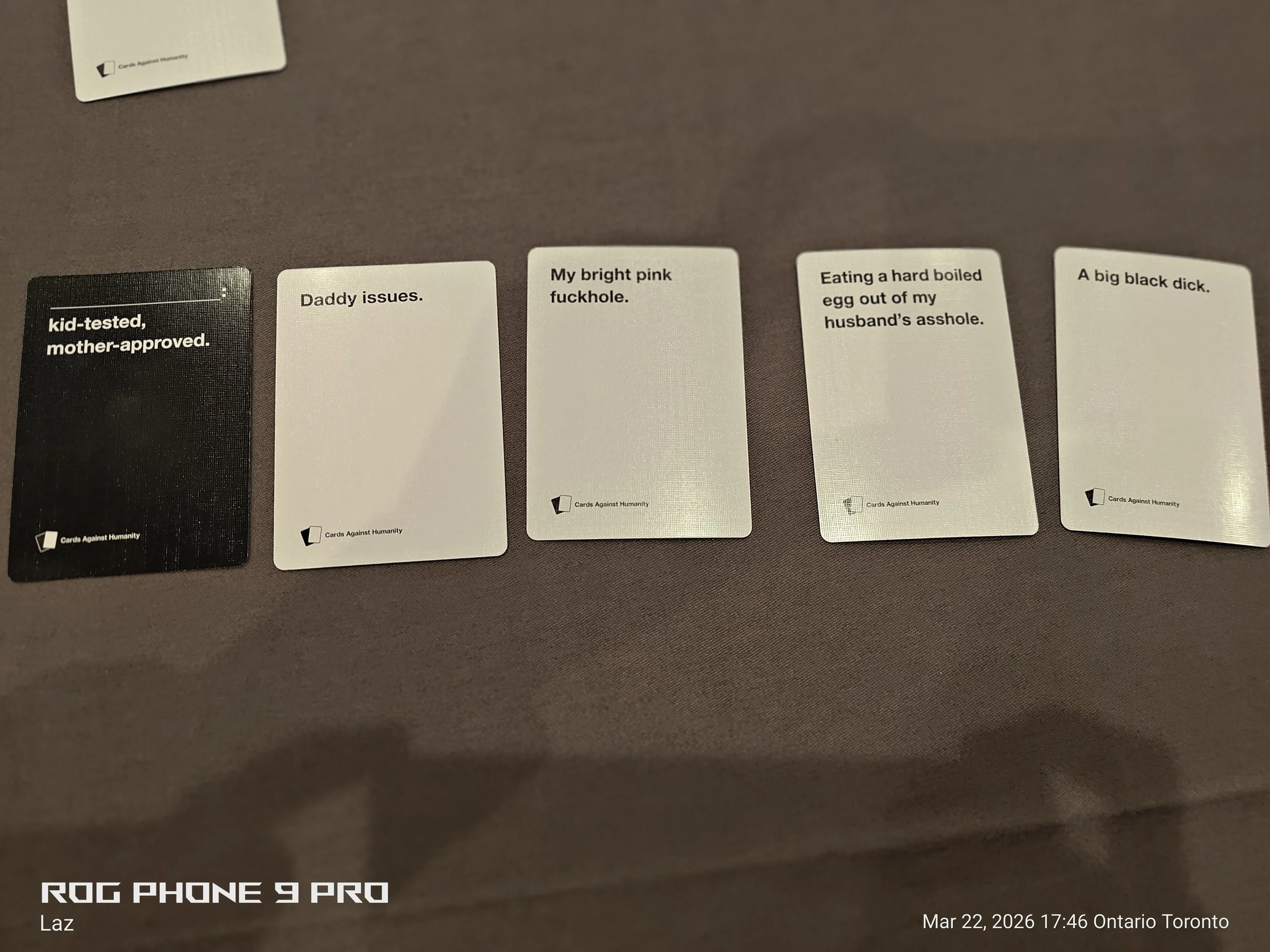 A series of cards with provocative statements on a brown surface.