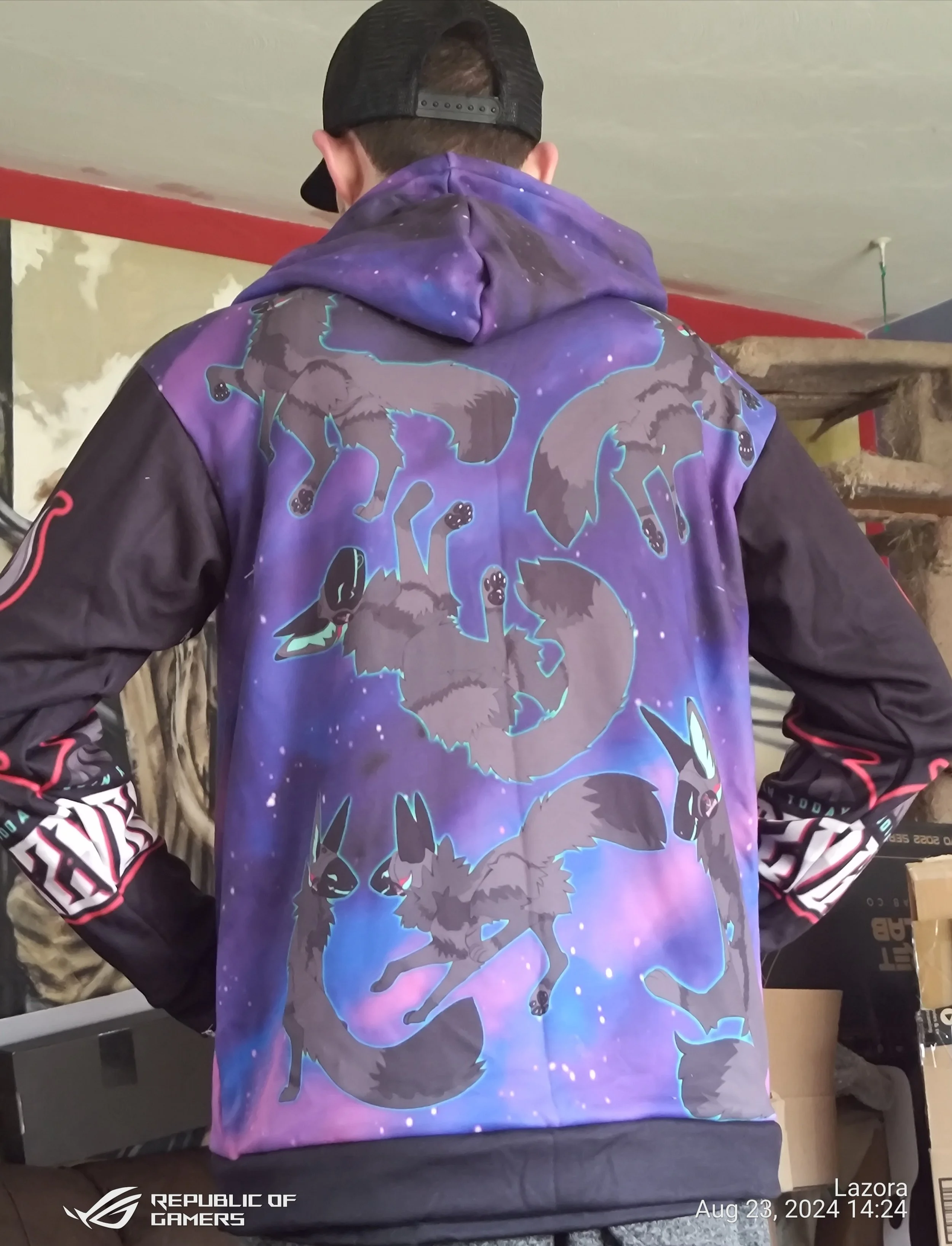 Back of a person wearing a black cap and a purple hoodie with galaxy and wolf design, standing indoors. The photo includes a timestamp and the Republic of Gamers logo.