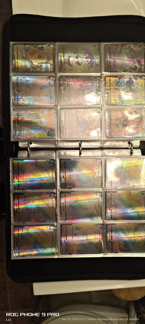 A Pokémon card collection in a binder featuring holographic cards of various Pokémon.