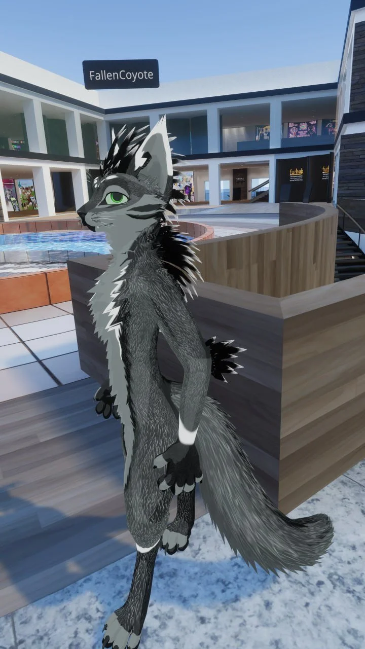 A digital illustration of a gray anthropomorphic feline with green eyes, standing outdoors near a modern building with a sign that reads 'FallenCoyote.'