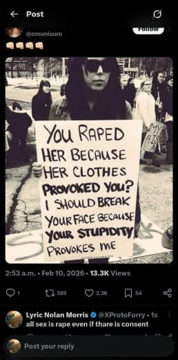 A woman holding a sign at a protest, the sign reads: 'You Raped Her Because Her Clothes Provoked You? I Should Break Your Face Because Your Stupidity Provokes Me.'