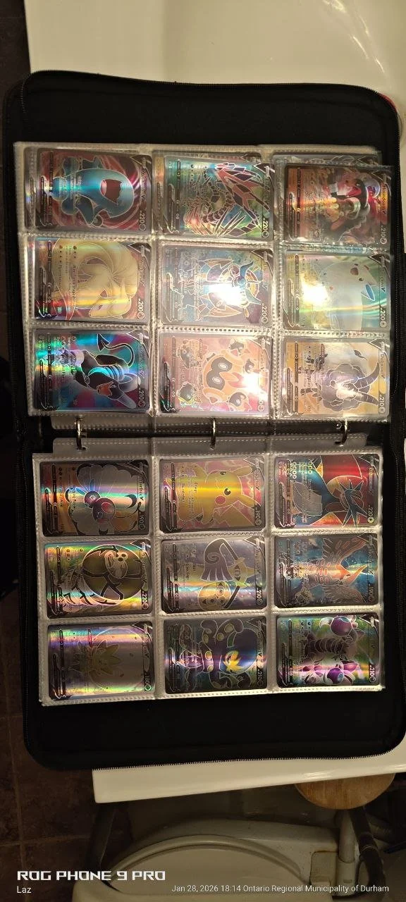 Collection of Pokémon cards in a binder, featuring various holographic and regular cards arranged in clear sleeves.