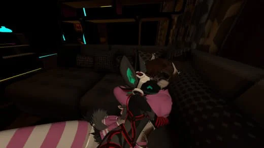 A cat hugging a small robot on a couch in a dimly lit room.