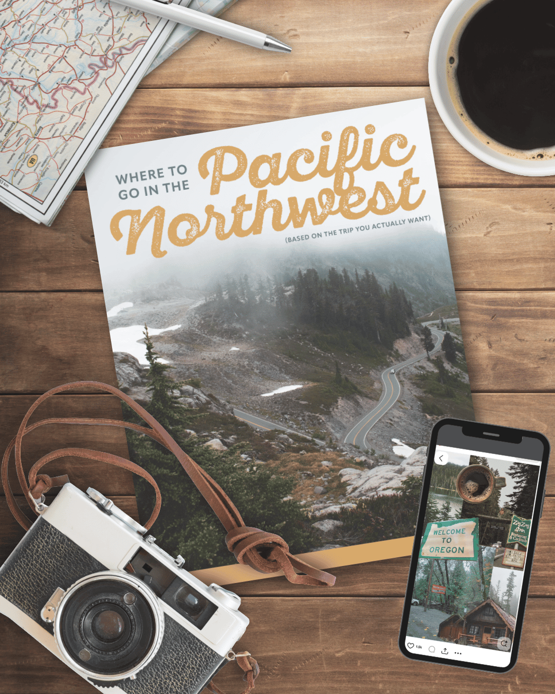 A wooden table with a map, a pen, a coffee cup, an Oregon travel brochure featuring a mountain road, a vintage camera with a leather strap, and a smartphone displaying a photo of an Oregon welcome sign and a cabin.