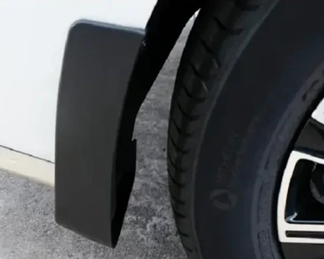 Close-up of a vehicle's tire and mud flap.