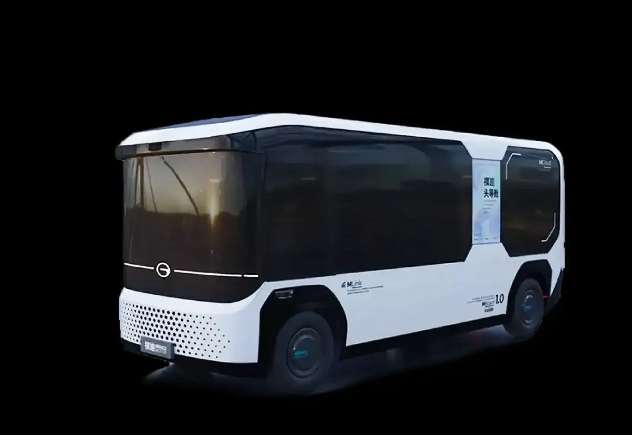 A futuristic autonomous electric shuttle bus with a sleek design, black tinted windows, and white body with minimal branding, set against a black background.
