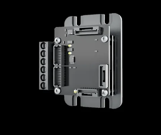 Close-up of an industrial electronic component with circuit ports and screws on a black background.