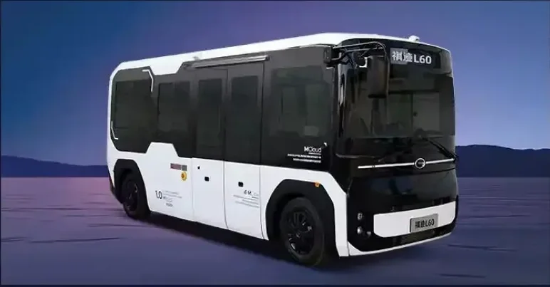An autonomous electric shuttle bus driving on a flat surface in a scenic outdoor setting with mountains in the background.