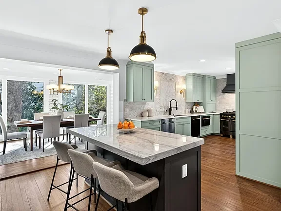 Modern kitchen with mint green cabinets, marble island, professionally staged by VIBE Designs in Greenville, SC.