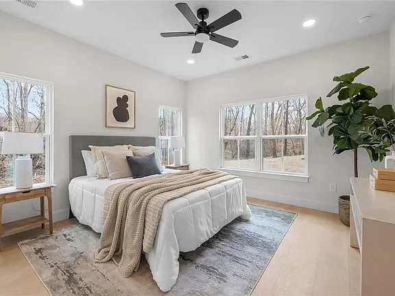 Bright bedroom with large windows professionally staged by VIBE Designs in Greenville, SC.