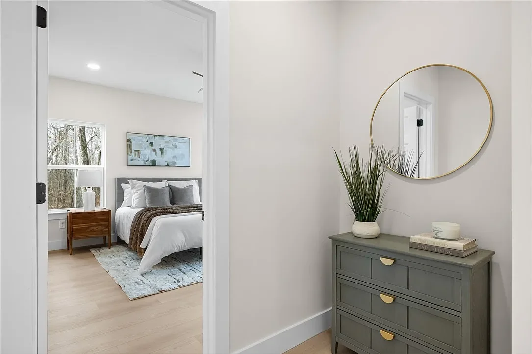 View of a bedroom seen through an open door, professionally staged by VIBE Designs in Greenville, SC.