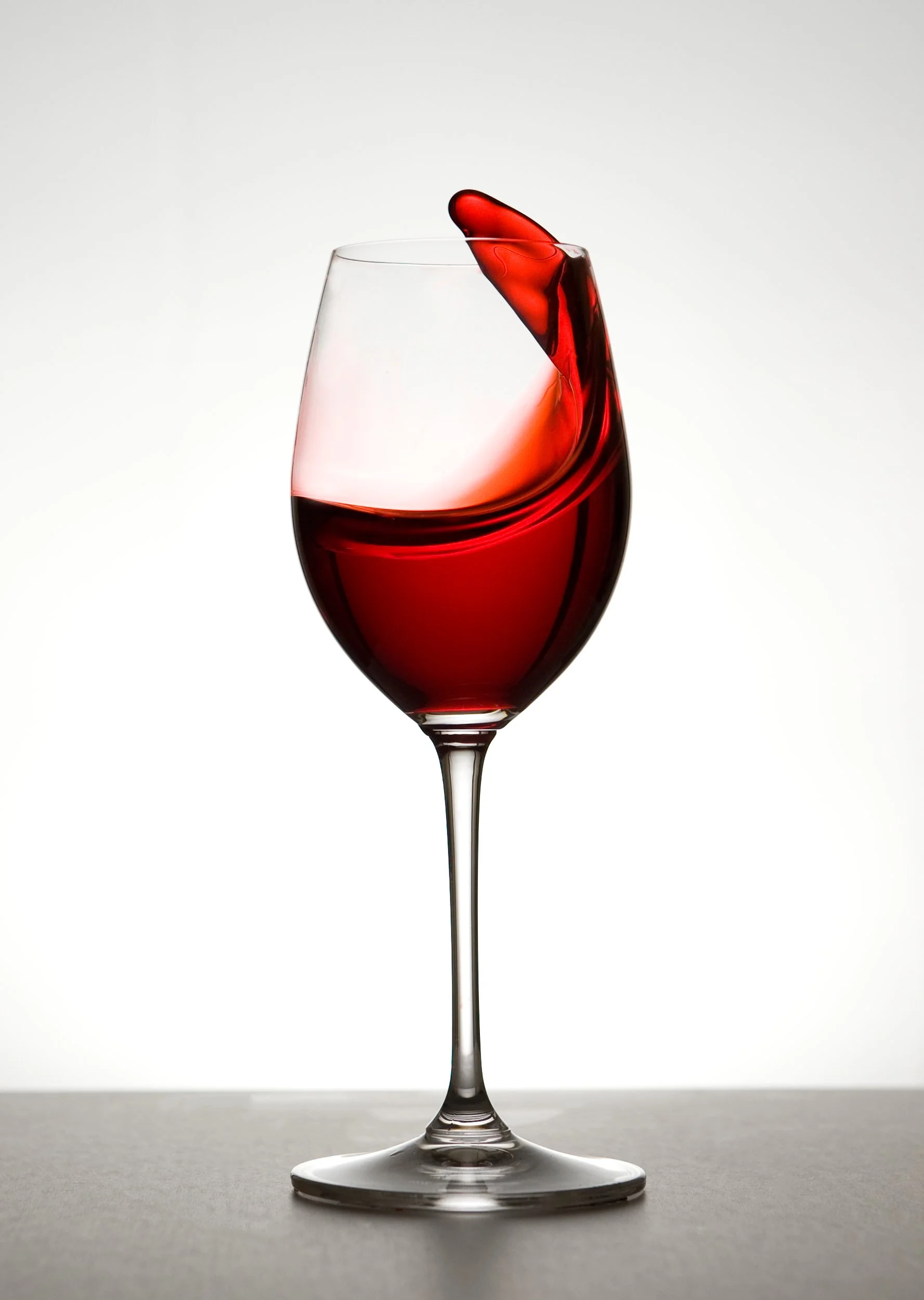 A glass of red wine mid pour - the brand hero image for The Cellar Schematic.