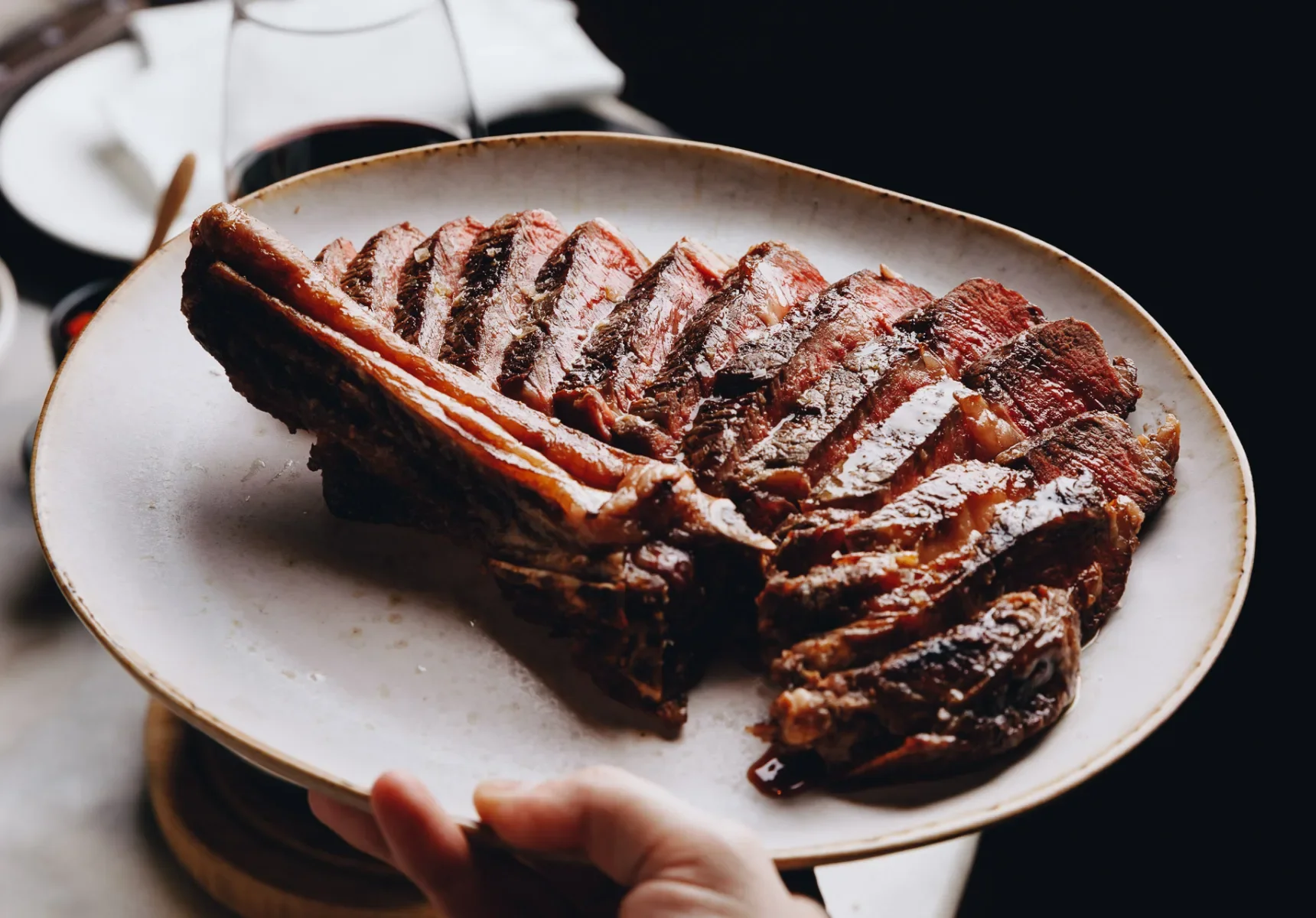 A plate of sliced, cooked beef with a dark glaze or sauce, served on a white ceramic plate.