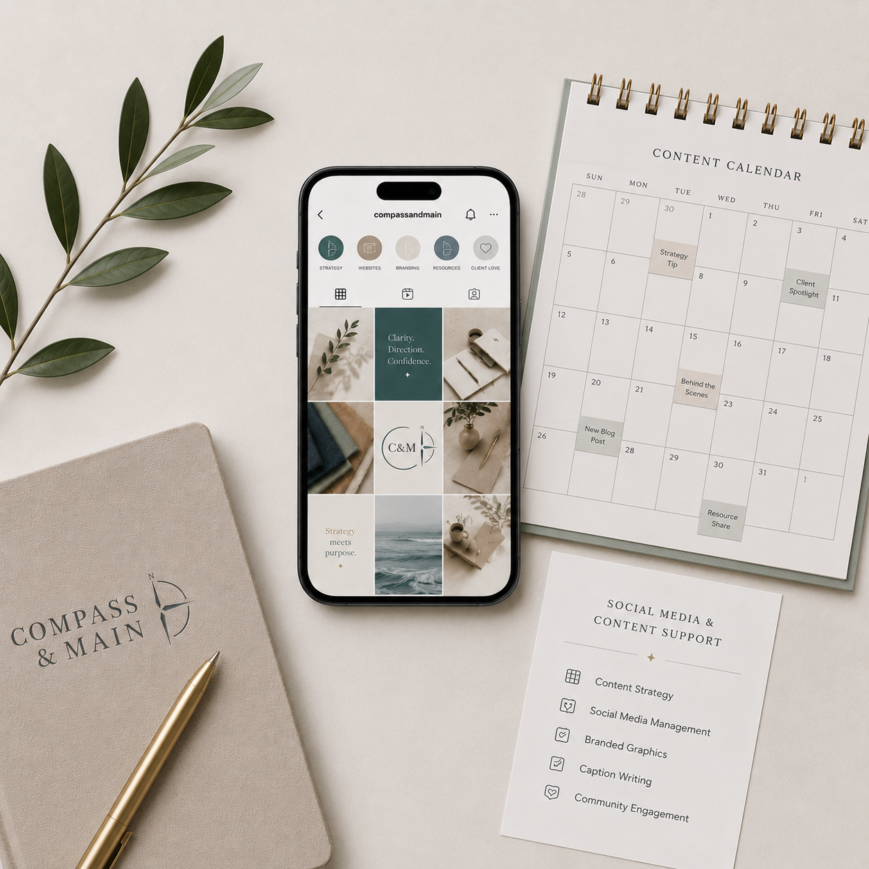 Social media planning materials with a smartphone, content calendar, and Compass & Main notebook.