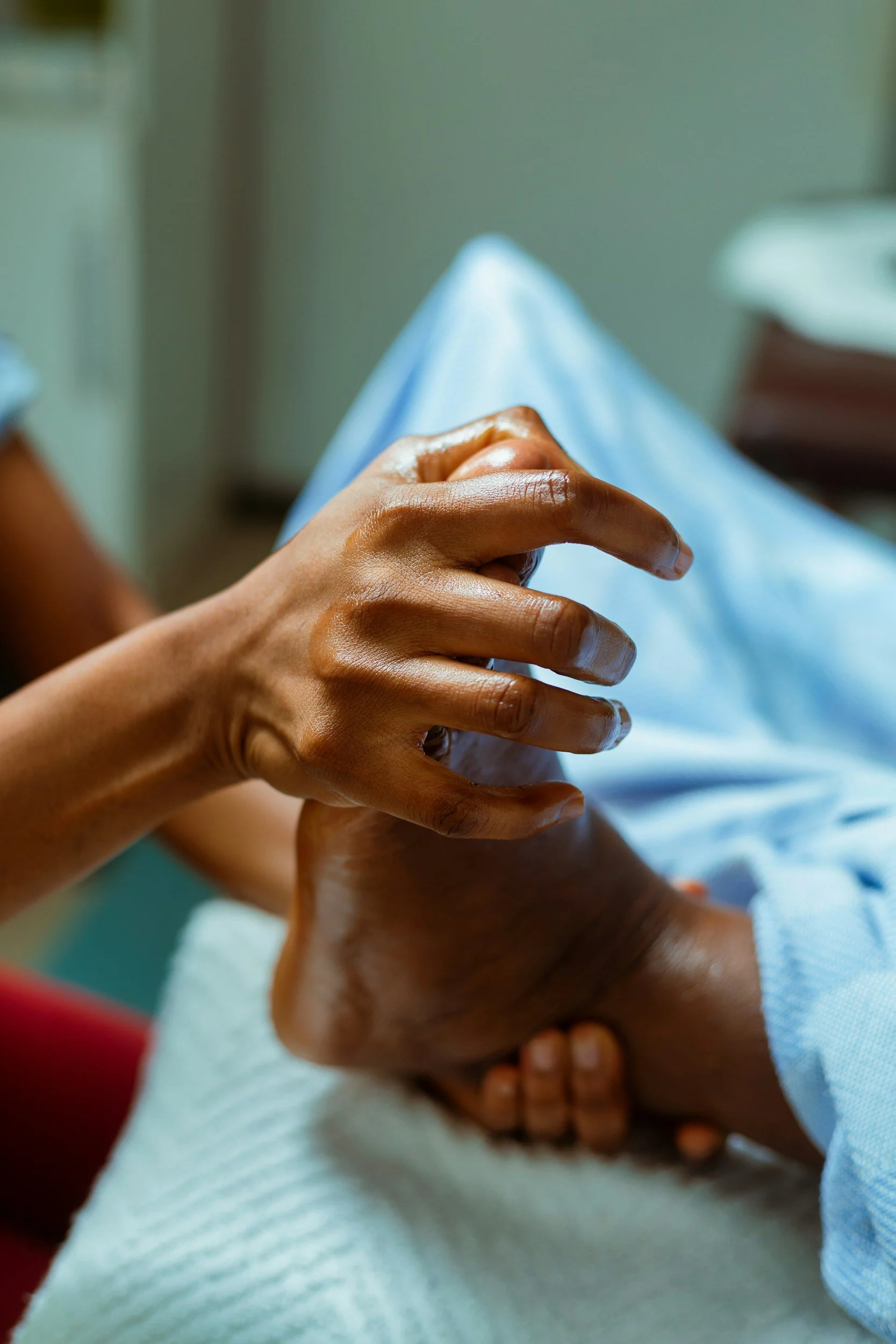 Close-up of a person receiving a hand massage or physical therapy from another individual in a clinical or spa setting.
