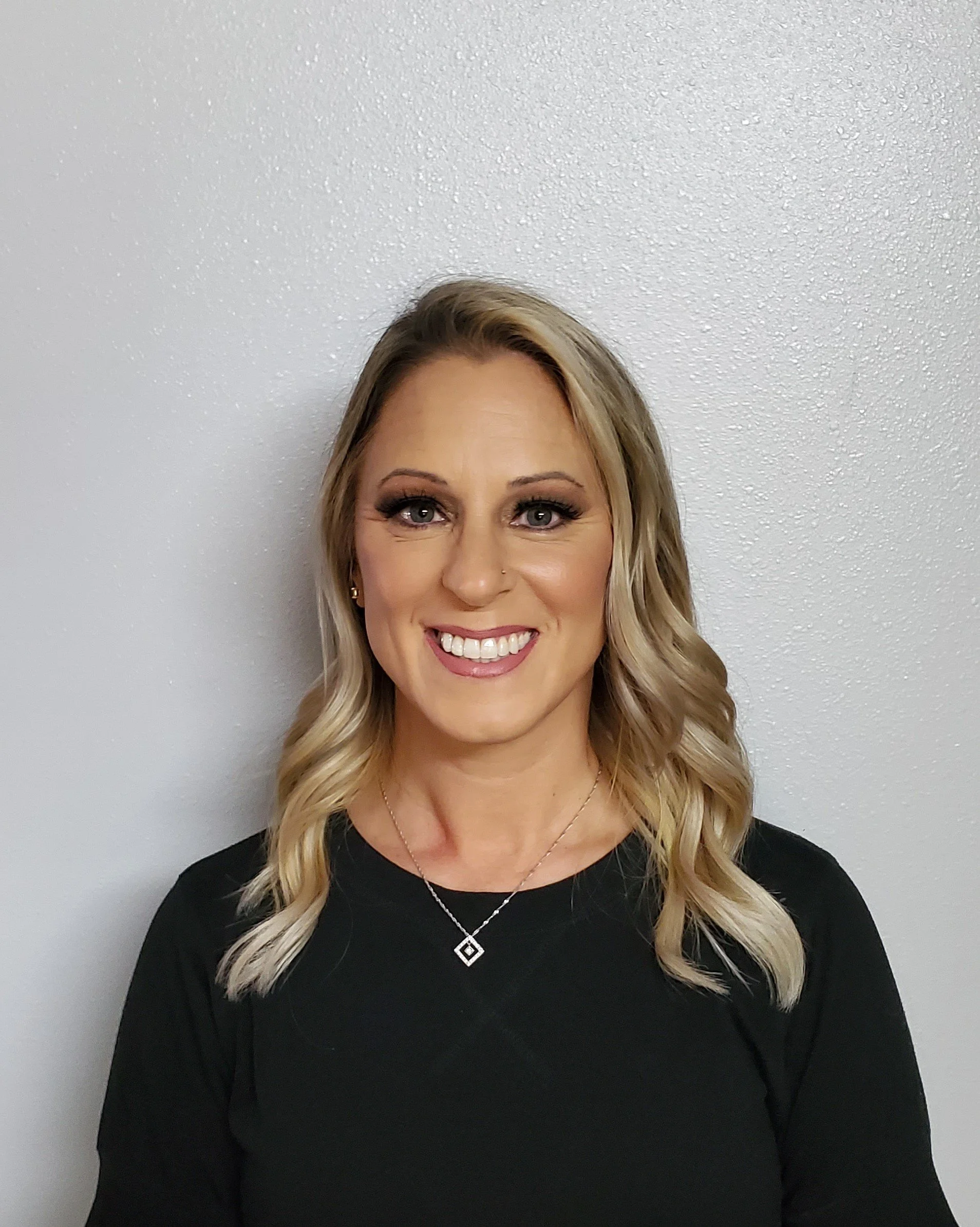 Heather is the owner of Nail Network School.  She has blonde hair and a black shirt with a simple necklace.