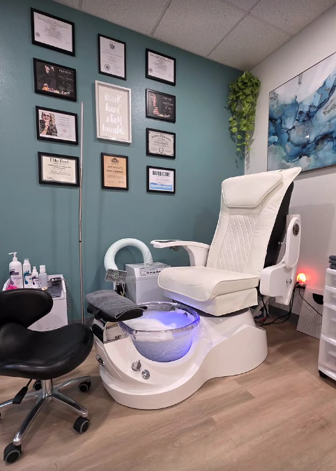 Nail salon pedicure chair with certificate frames on teal wall, this is a professional nail salon set up.