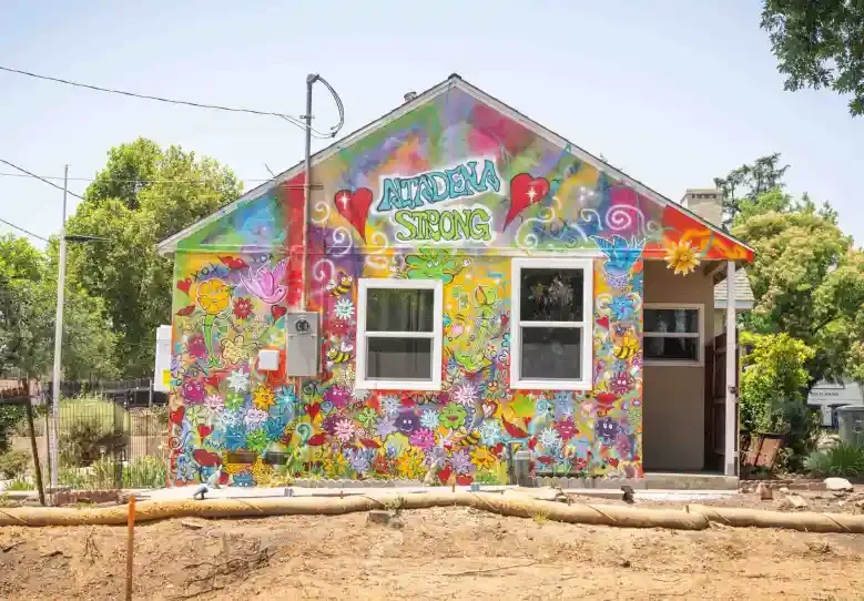 A house painted as a colorful mural, recognizing the Altadena Strong movement.