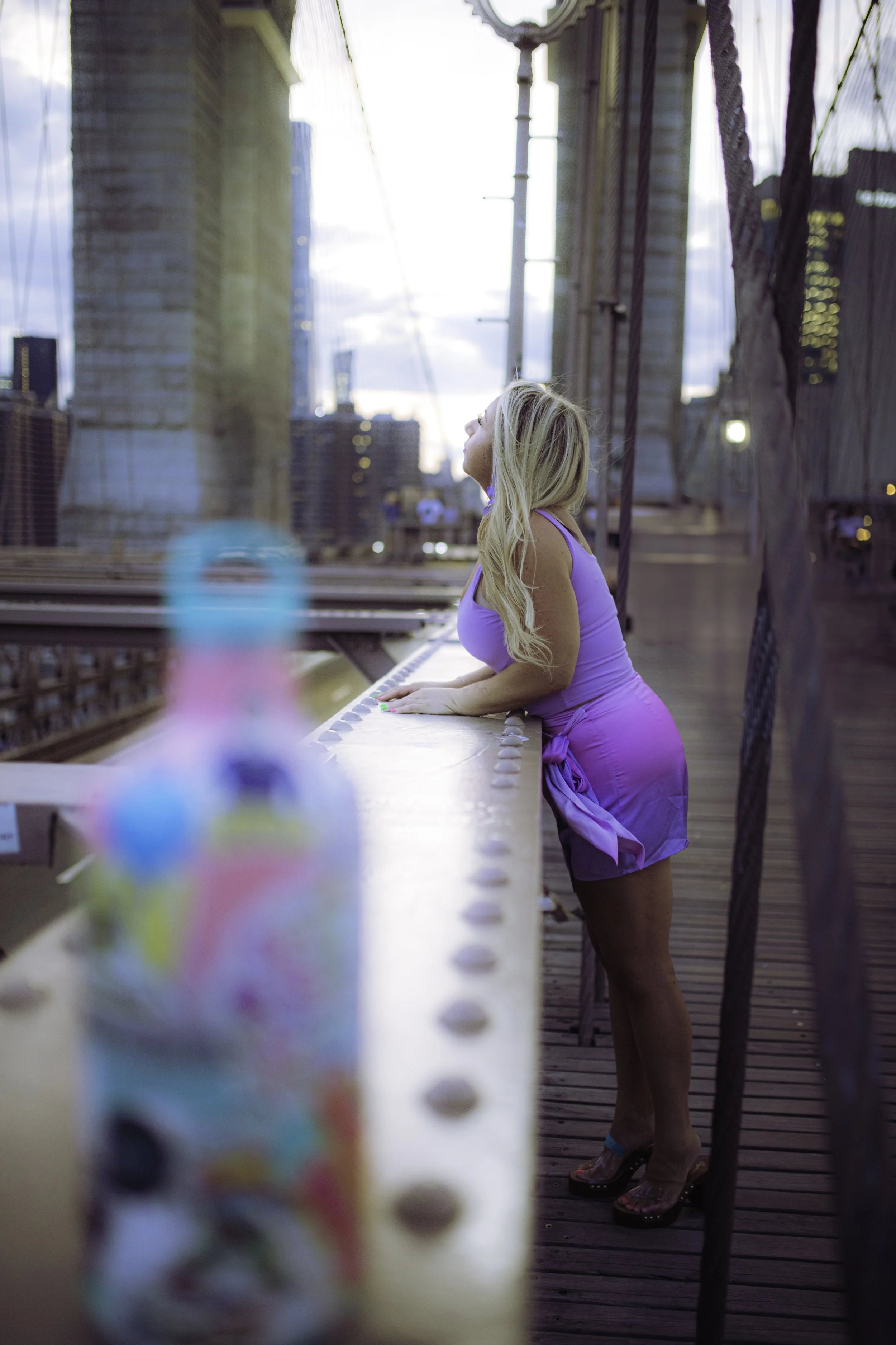 Lauren in purple dress on Brooklyn Bridge, evening view