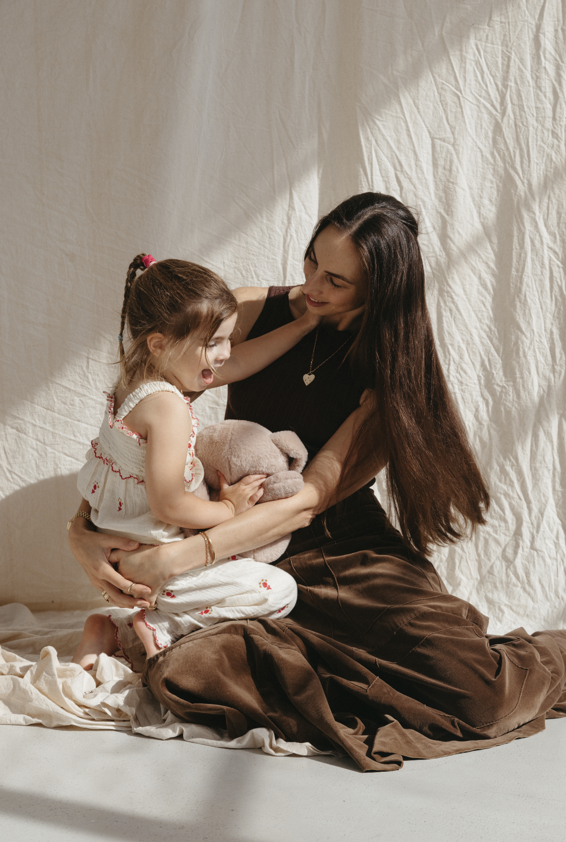 Motherhood Podcast host Tania Gnecchi, sitting on the floor with her daughter Noa.