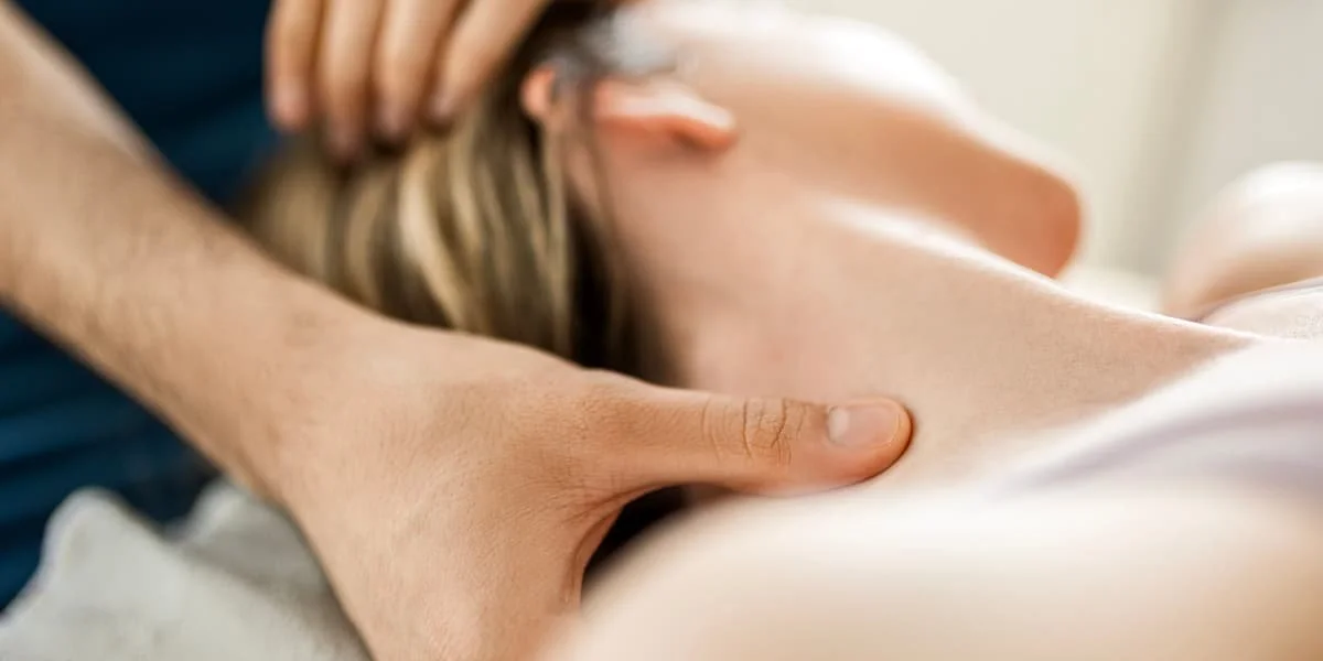 Person receiving a massage on their shoulder from a massage therapist.