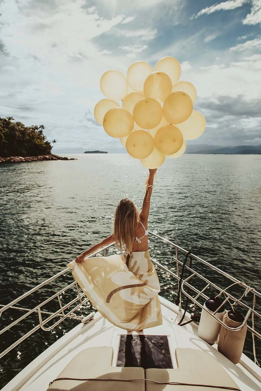 Person holding yellow balloons on a boat, symbolising confidence and optimism during life's major financial transitions with Up Wealth Management