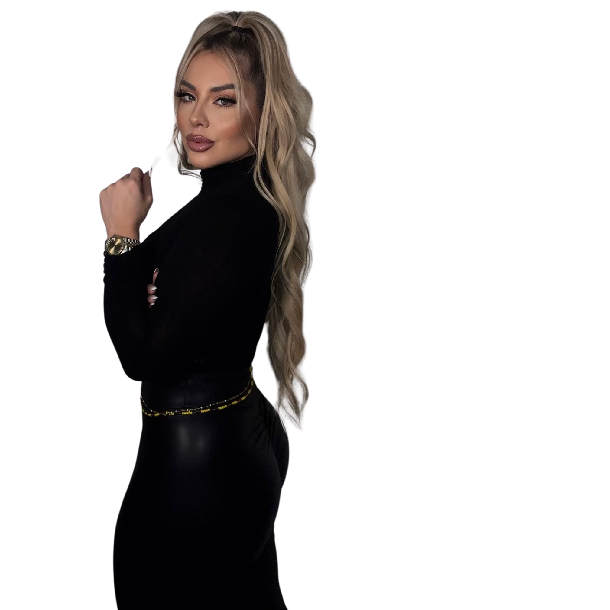 A woman with long, wavy blonde hair styled in a high ponytail, wearing makeup with bold eyebrows, eyeliner, and glossy lips, dressed in a black turtleneck top and accessorized with a gold watch and bracelet, posing confidently against a black background.