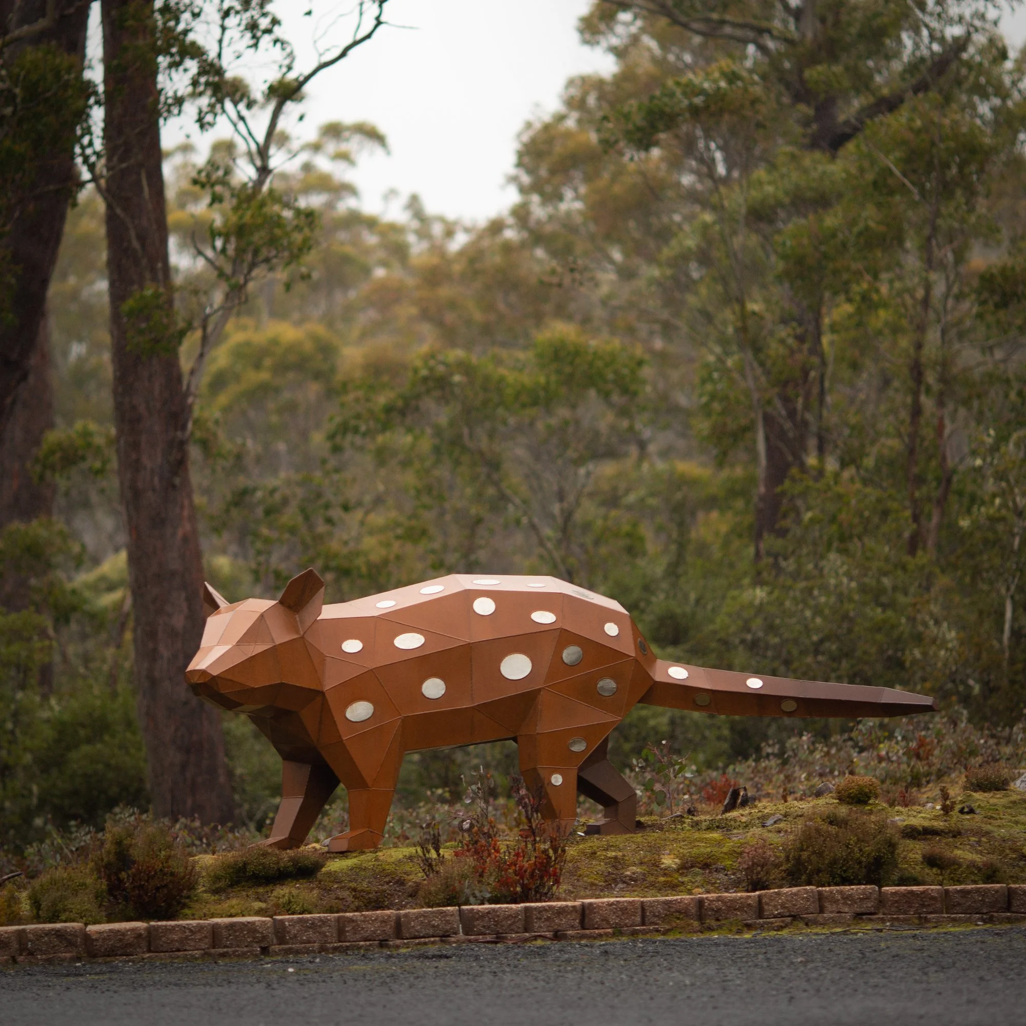 corten and stainless steel low poly spotted quoll sculpture in the central highlands tasmania