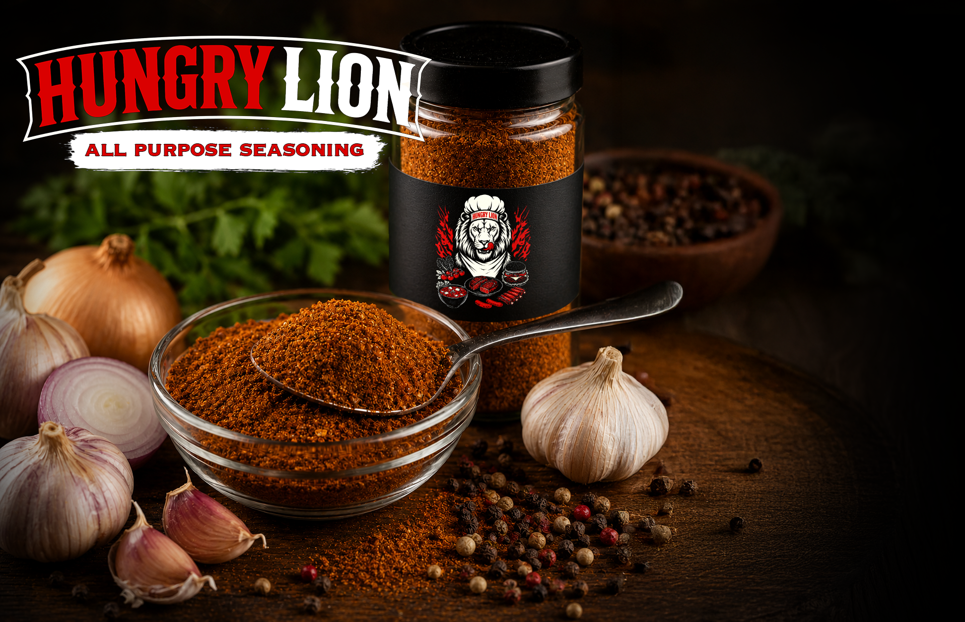 A jar of Hungry Lion all-purpose seasoning on a wooden surface, with garlic bulbs, onions, and mixed peppercorns scattered around, and a small bowl of ground seasoning in the foreground.