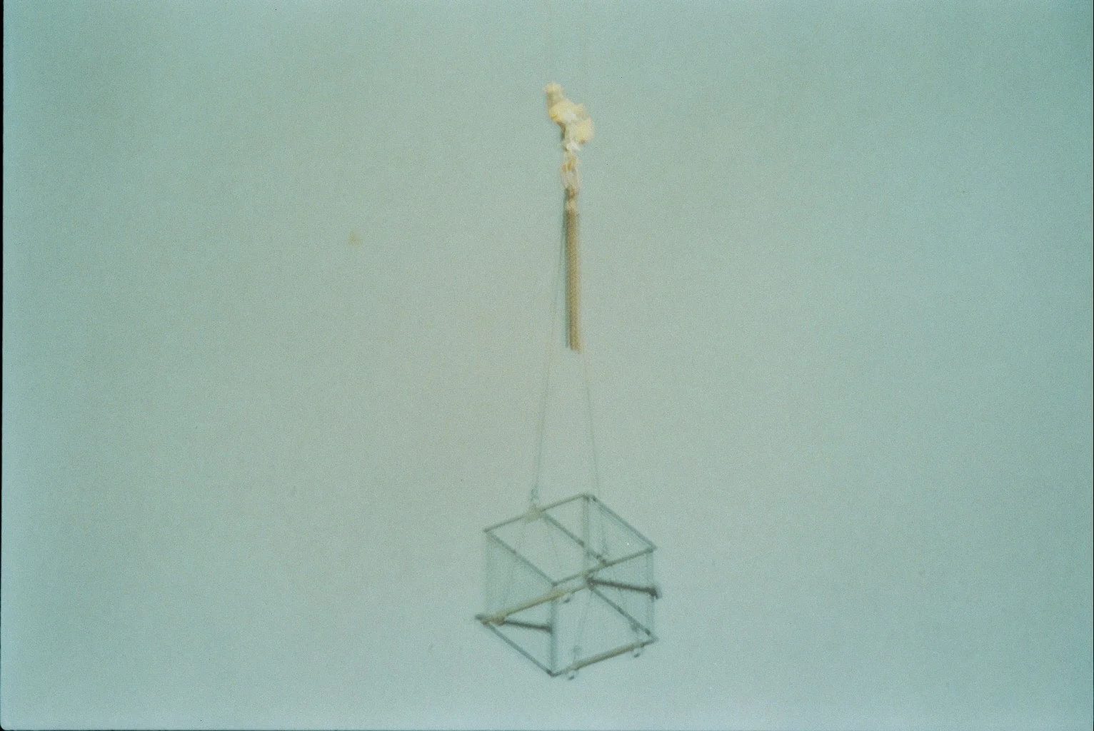 A ceiling-mounted metal geometric mobile sculpture hanging in a room with a light-colored ceiling.