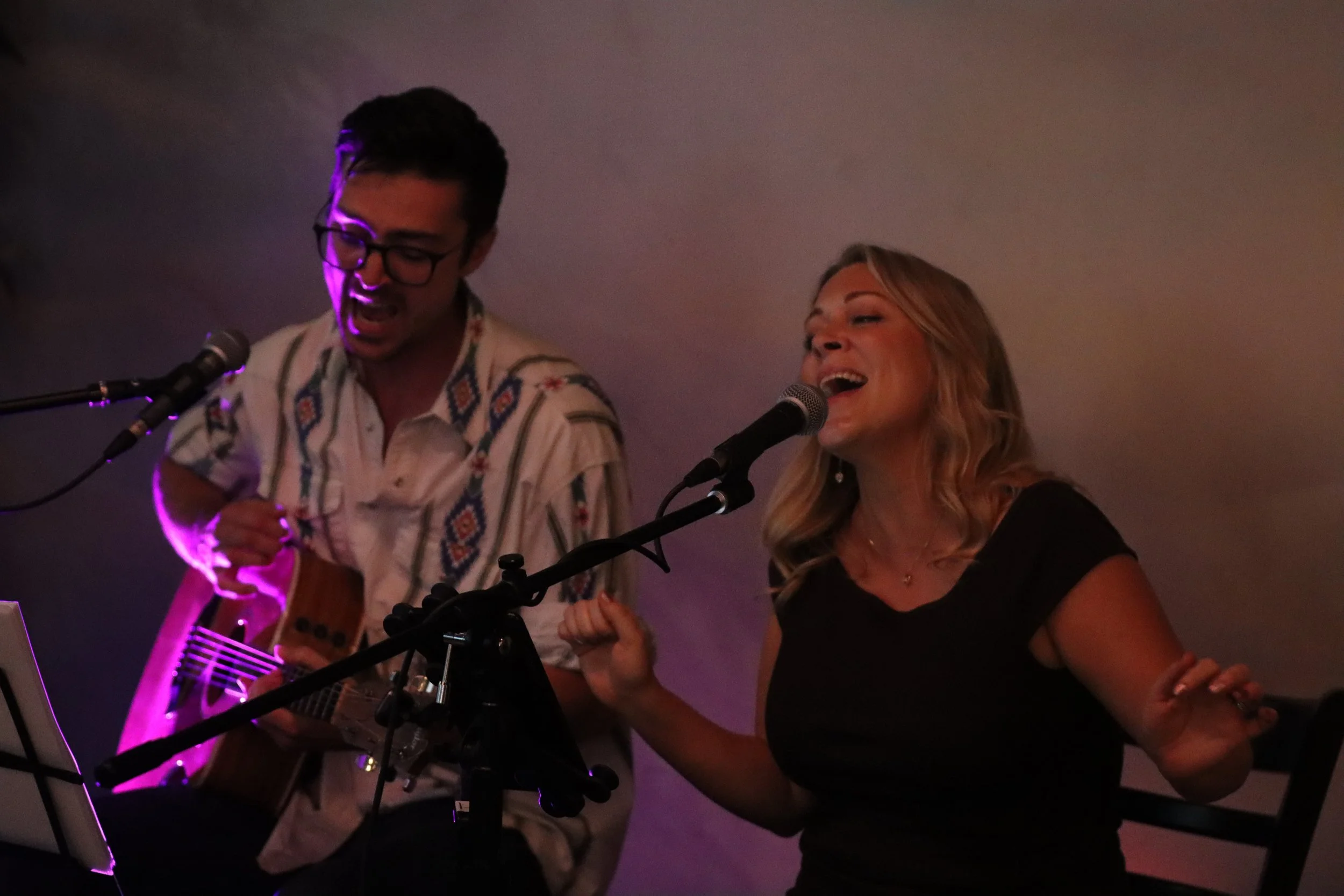 Kelly and Hedley performing on stage. Kelly Nicholas. Hedley Nelson. Kelly and Hedley acoustic duo.