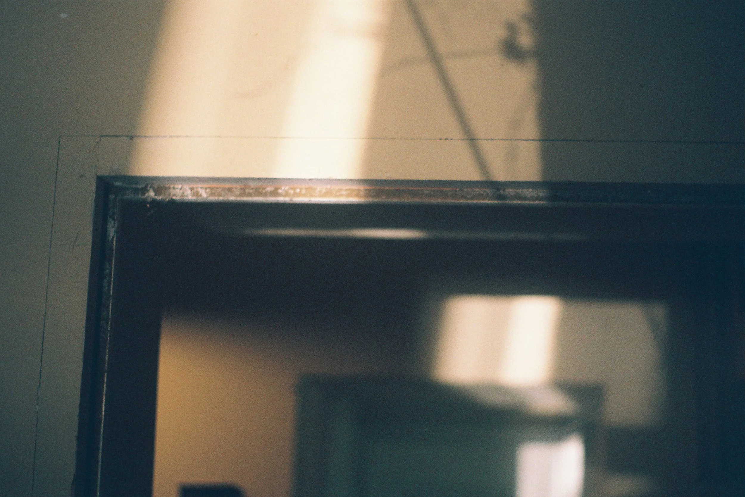 Close-up of an elevator door with reflections and shadows on the metallic surface.