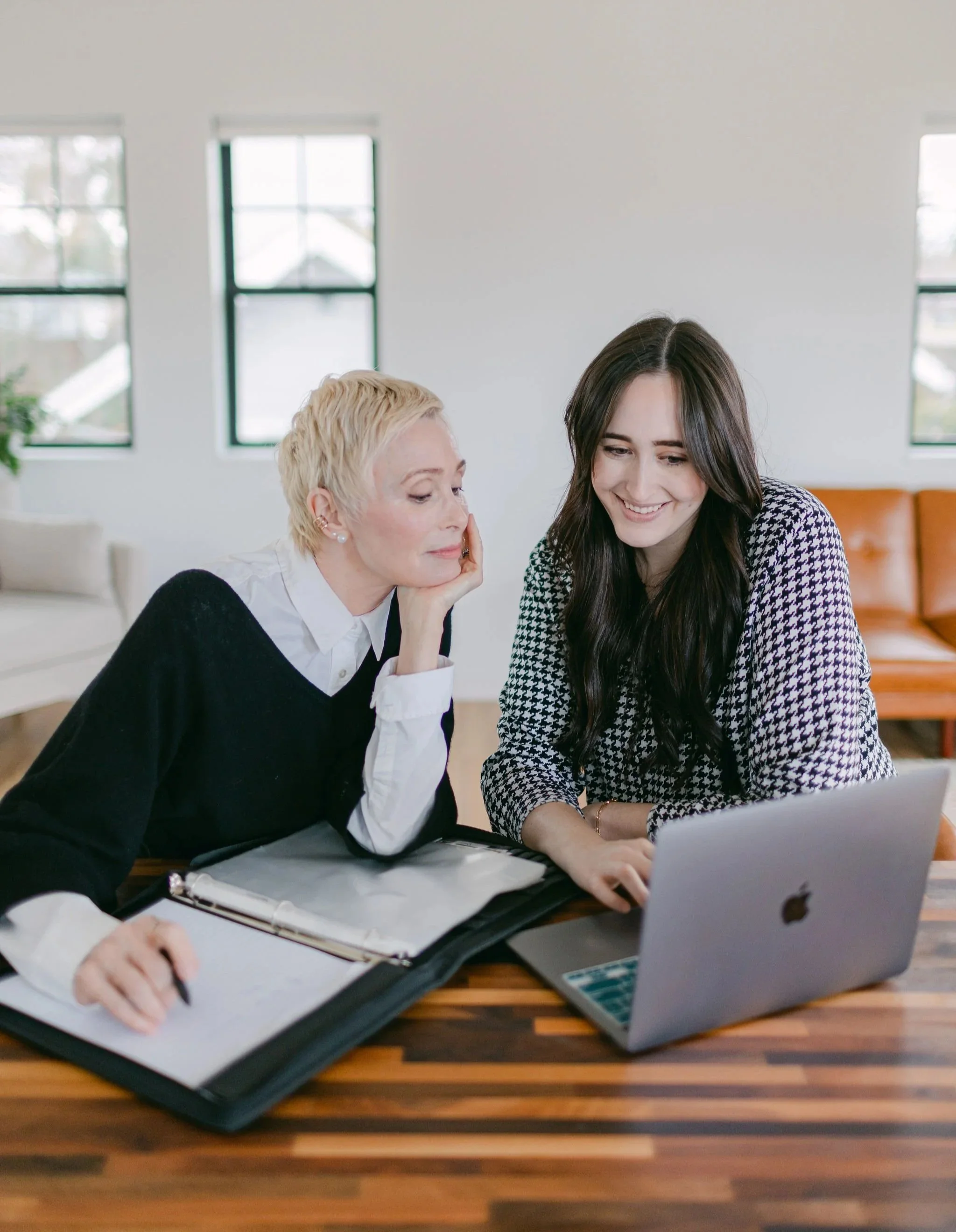 Fiona and Kate of Weddings Unlocked working together at a laptop in a sunlit room