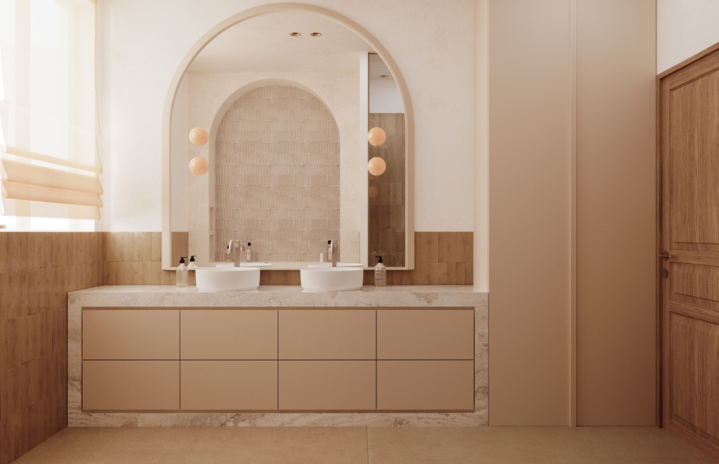 Lavabo double avec deux robinets, grand miroir mural, éclairage suspendu, vasques blanches, meubles de rangement beige, murs en pierre et bois naturel.