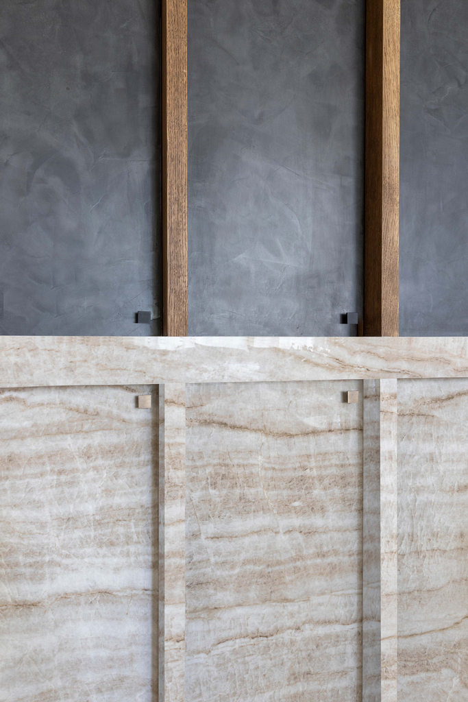 Partition murale en marbre beige avec deux supports en bois sur un mur gris