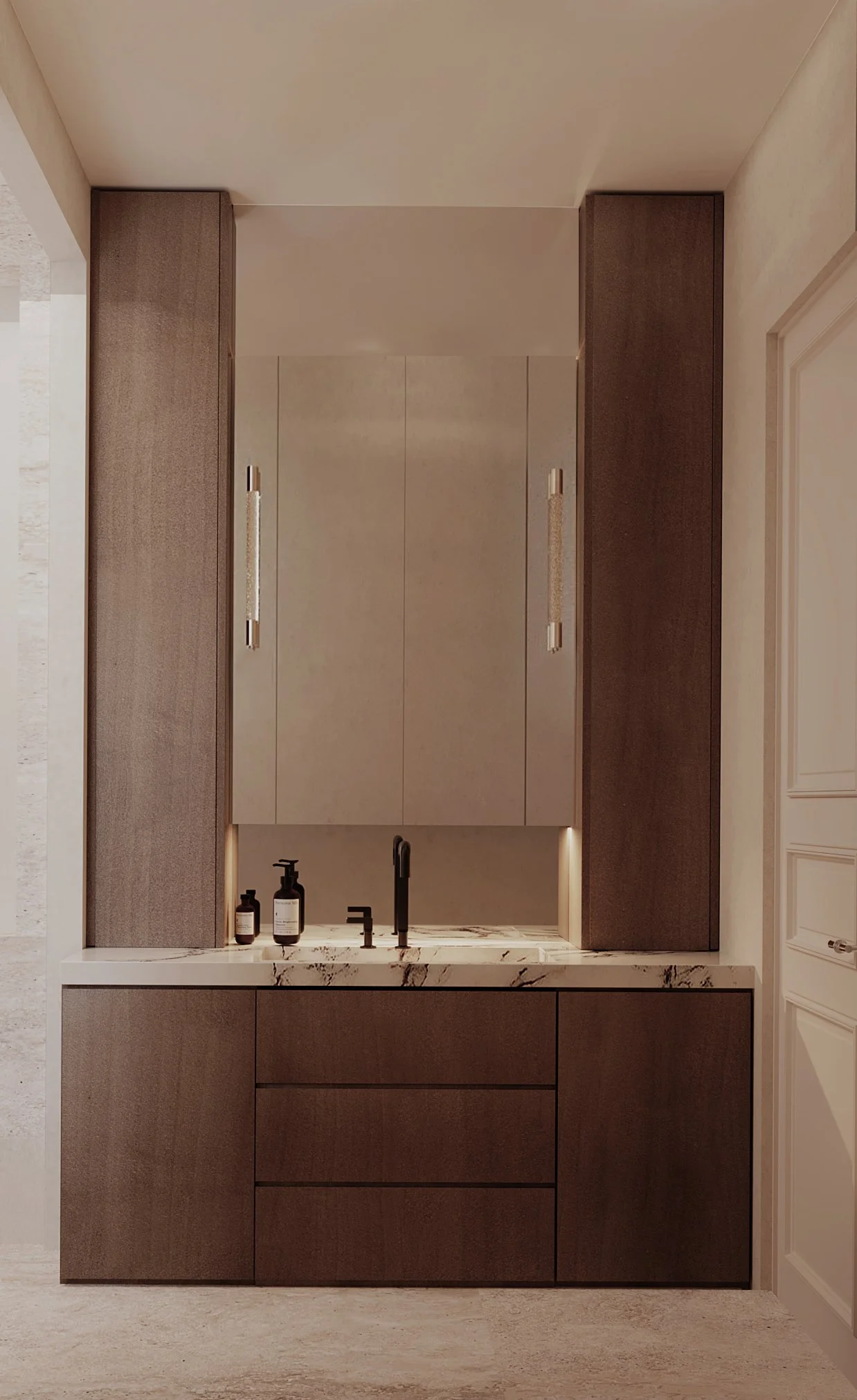 Un meuble de salle de bain moderne avec un évier en marbre, un robinet noir et des bouteilles de savon ou de lotion, avec des armoires en bois foncé et deux armoires murales claires.