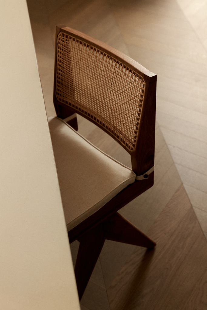 Chaise en bois avec dossier en cannage et assise rembourrée, vue partielle