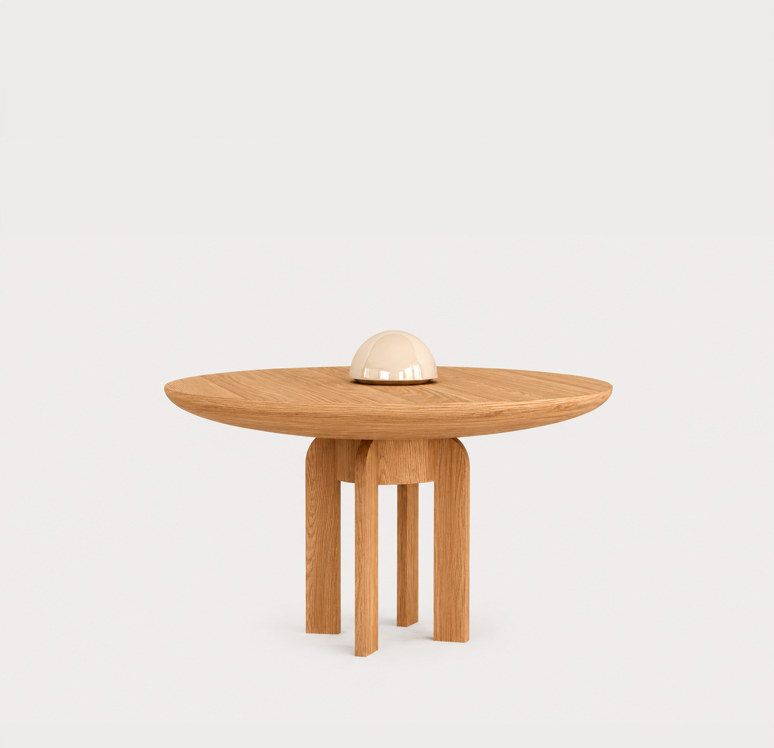 Table en bois avec une base en forme de trépied, surface ronde et un objet blanc arrondi dessus, ambiance minimaliste.