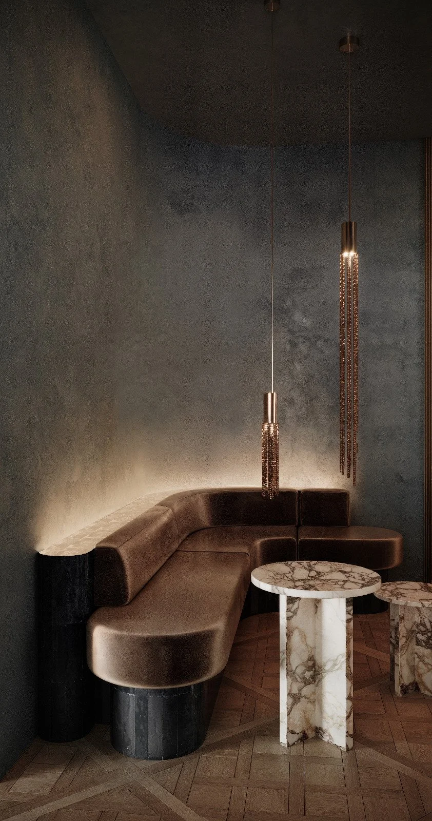 Coin salon avec un canapé en cuir beige, deux tables basses en marbre, et deux suspensions suspendues en métal ornées de chaînes.