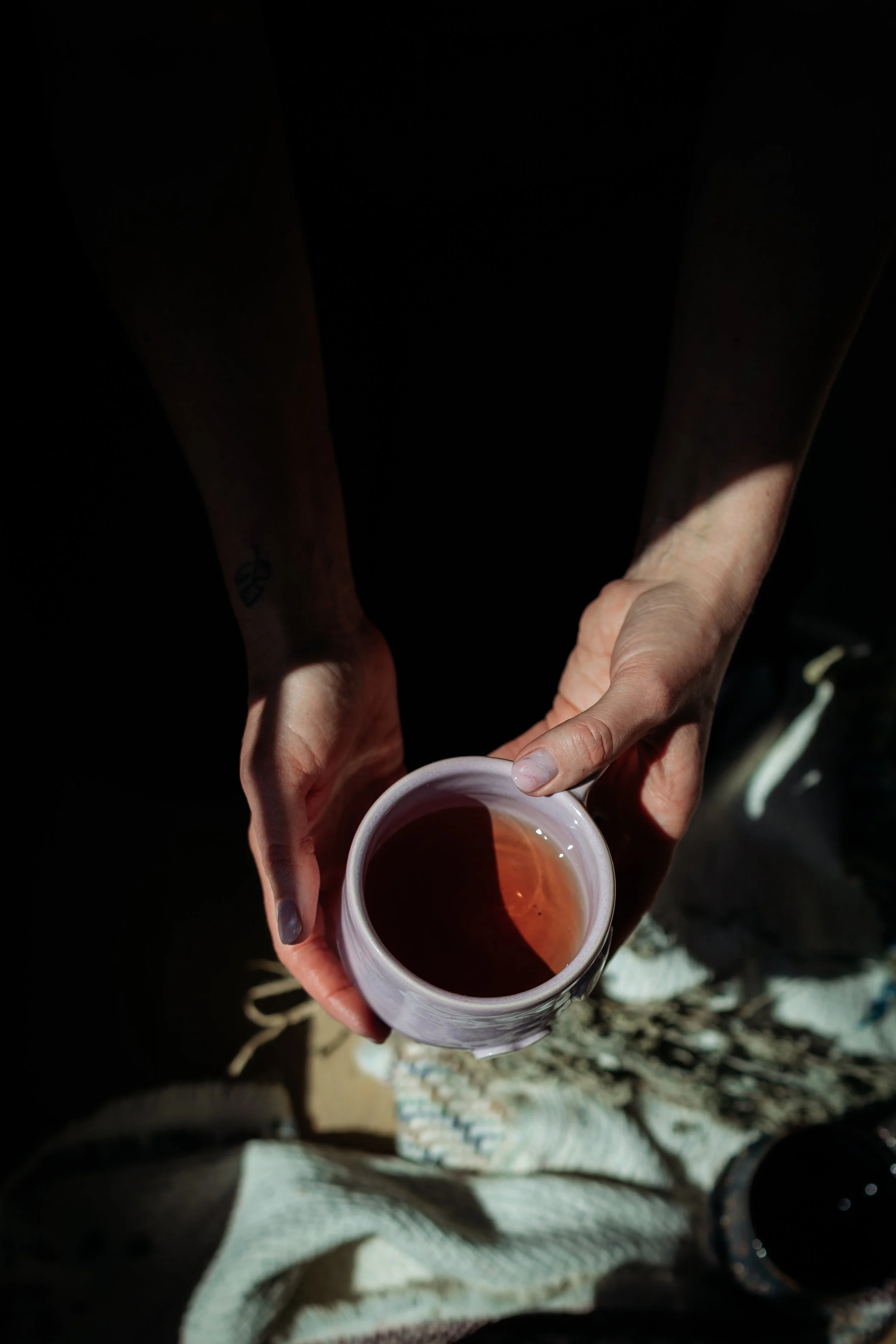 Woman holding cup of tea during a gathering event at Gathered Hearth, Prince Albert Community Events & Workshops