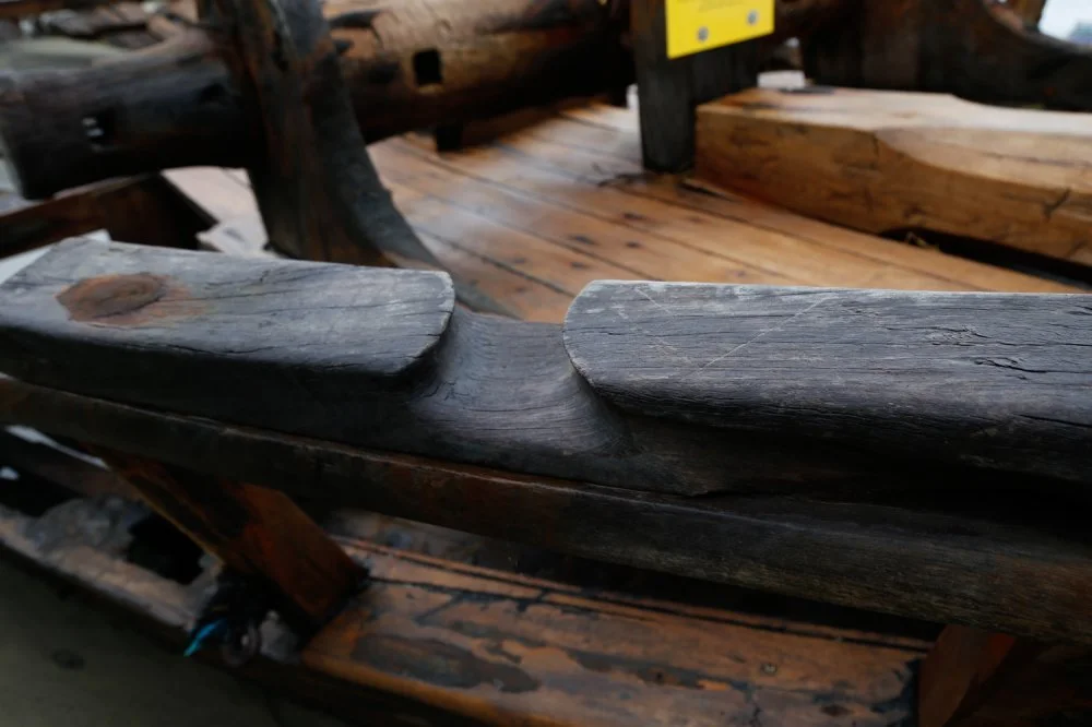 Close-up of a wooden handrail on a rustic wooden observation deck or walkway.