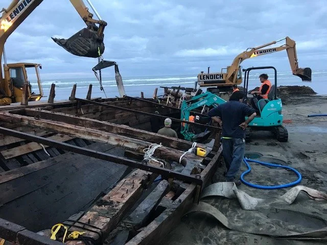 Removing the sand from within the hull hoping the next tide doesn't refill it.